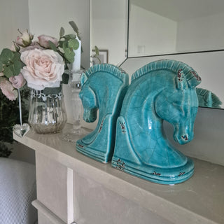 Ceramic horse head bookends with intricate detailing in a calming blue glaze styled on a mantle with faux flowers and beveled mirror - available to buy online or instore from www.lilybloom.ie