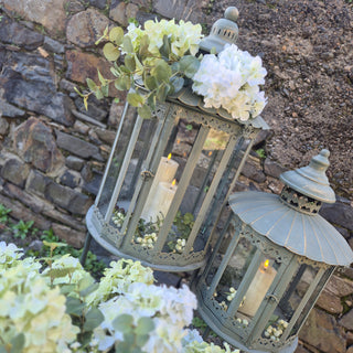 Set of 2 Heritage Lanterns from Lily Bloom with distressed grey-green finish, featuring large (H:1300mm) and small (H:1070mm) lanterns. Ideal for candles or fairy lights. Available at www.lilybloom.ie.